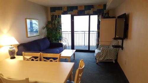 een woonkamer met een bank en een tafel en stoelen bij JeffsCondos - 3 Bedroom - Breakers Resort in Myrtle Beach