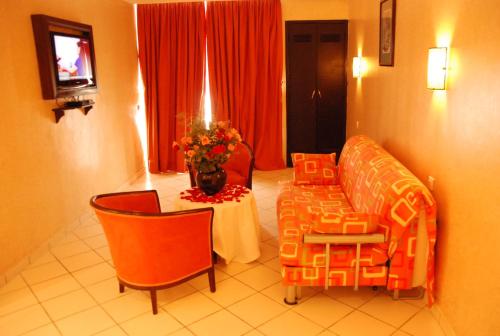 a living room with a couch and a table with flowers at New Farah Hotel in Agadir