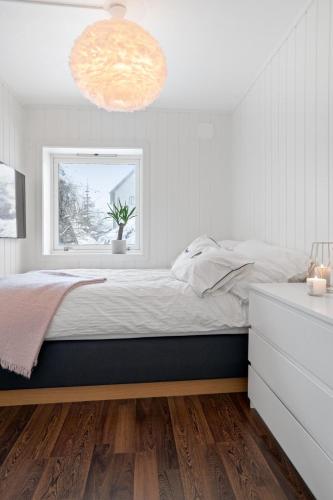 a bedroom with a large bed and a window at Modern apartment Tromsø in Tromsø