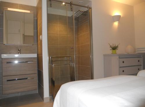 - une douche avec une porte en verre dans la chambre dans l'établissement Farniente, au Lavandou