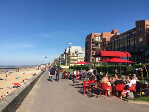 a group of people sitting in chairs at a beach at Chez Fany et Ben in Cabourg