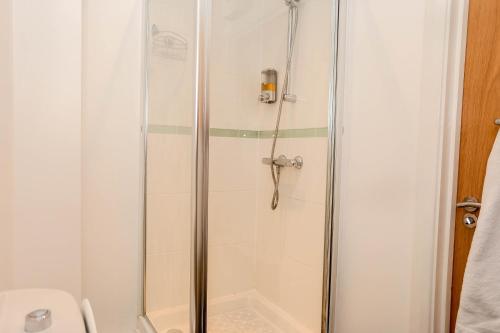 a shower with a glass door in a bathroom at Freyas in Manchester