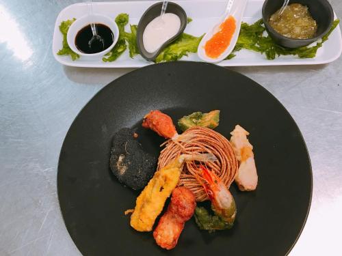 a black plate with food on a table at Puntaquattroventi in Ercolano