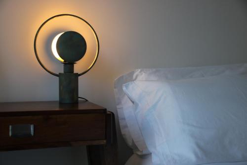 a lamp on a night stand next to a bed at Quinta Tagus in Costa da Caparica