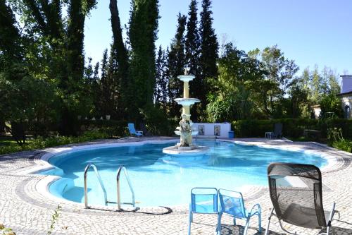 a swimming pool with a fountain in a yard at Quinta de Coalhos TH in Abrantes