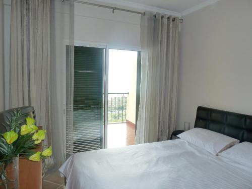 een slaapkamer met een wit bed en een balkon bij Oceanic Apartment in Caniço
