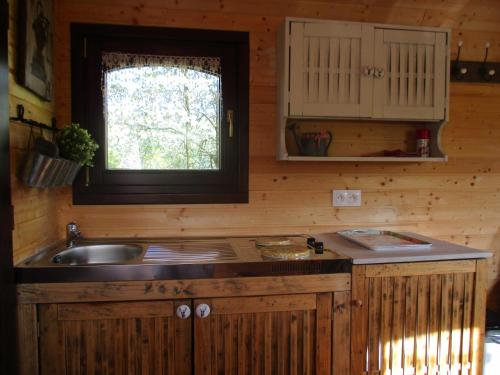 a kitchen with a sink and a window at Roulotte panoramique du Moulin in Châtillon-sur-Marne
