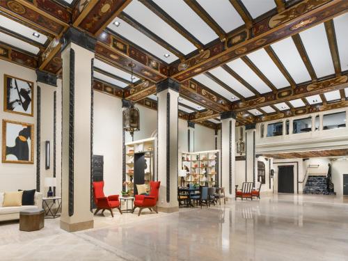 a large lobby with red chairs and tables at Hotel Spero, Vignette Collection by IHG in San Francisco
