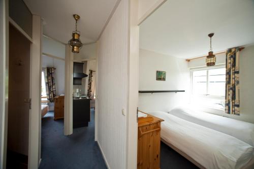 a bedroom with two beds and a window at Hanzehuis Appartementen in Stavoren