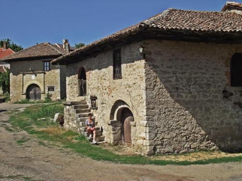 a man sitting in the doorway of a stone building at Vila Milenovic Rajacke Pivnice in Rajac