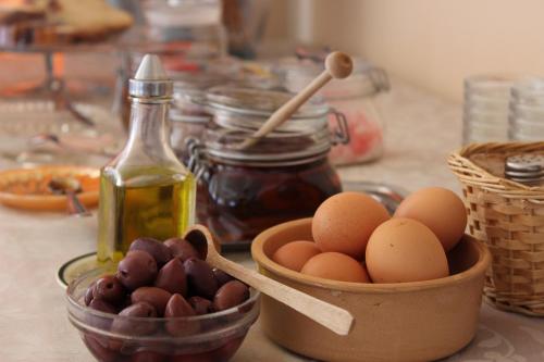 a table with a bowl of eggs and a bowl of nuts at Andromeda Hotel Apartments in Kos Town