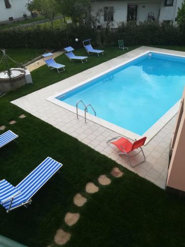 a large swimming pool with chairs and a lawn with at Villa Franco in Orentano