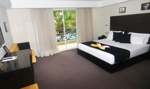 a hotel room with a bed and a window at Savoy Hotel Boutique in Las Terrenas