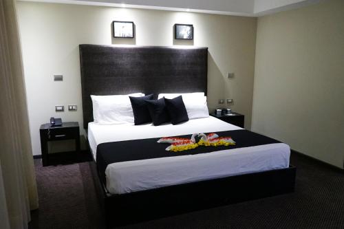 a hotel room with a large bed with shoes on it at Savoy Hotel Boutique in Las Terrenas