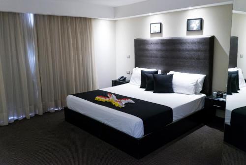 a hotel room with a large bed with a black headboard at Savoy Hotel Boutique in Las Terrenas
