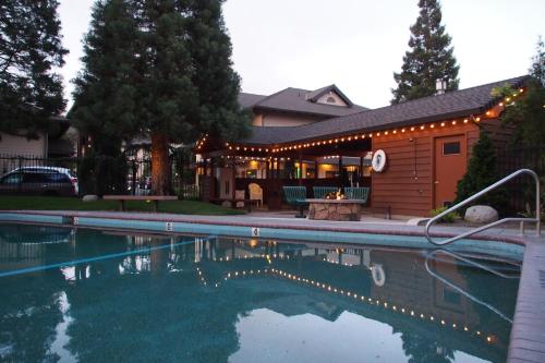 a swimming pool in front of a house at Redwood Hyperion Suites in Grants Pass