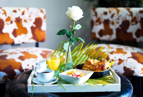 a coffee table with a tray of food and a flower at Savoy Hotel Boutique in Las Terrenas