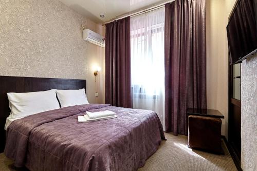 クラスノダールにあるHotel Altayのベッドと窓が備わるホテルルーム
