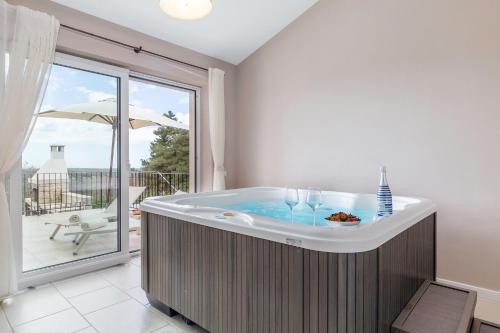 a jacuzzi tub in a room with a balcony at Villa Sterpazzi - near Porec with Sea View, private Jacuzzi, Sauna and Pool in Višnjan
