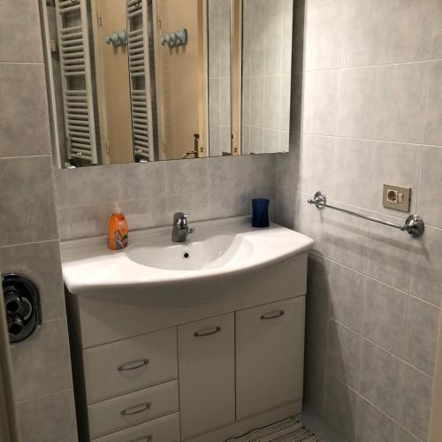 une salle de bain avec un lavabo blanc et un miroir dans l'établissement Le Vina del Mar Bloc B, à Menton