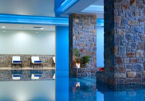 a lobby with a stone wall and a pool at Summer Villas Crete in Balíon
