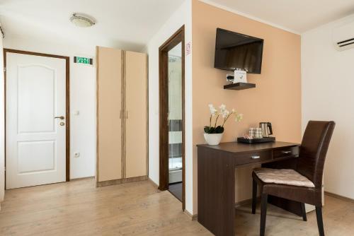 a room with a desk with a chair and a television at Guesthouse Imperator in Split