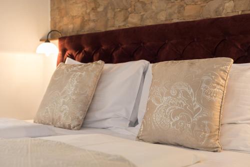 a bed with white pillows and a brown headboard at Guesthouse Imperator in Split