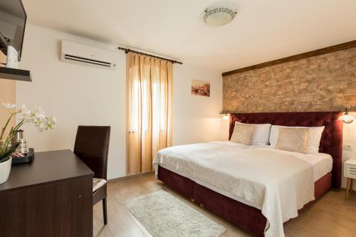 a hotel room with a bed and a desk at Guesthouse Imperator in Split