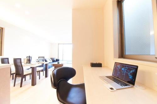 an office with a desk with a laptop on a table at Kyoto river side modern House in Kyoto
