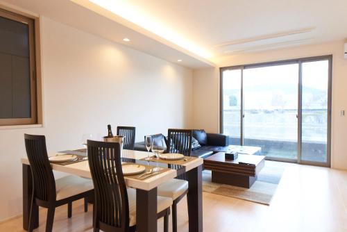 a living room with a table and a couch at Kyoto river side modern House in Kyoto