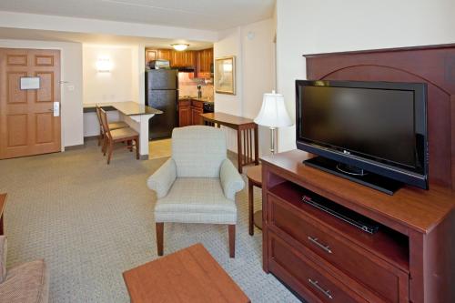 a living room with a flat screen tv on a dresser at Staybridge Suites Indianapolis Downtown-Convention Center by IHG in Indianapolis