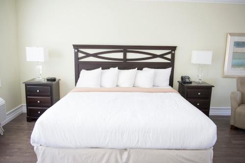 a bedroom with a large white bed with two night stands at Sands on Golden Lake in Golden Lake
