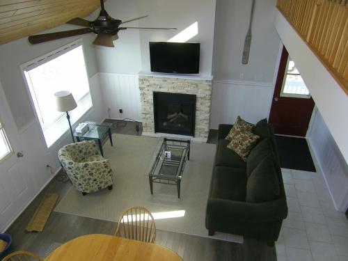 a living room with a couch and a fireplace at Sands on Golden Lake in Golden Lake