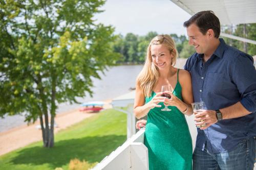 a man and woman standing on a porch drinking wine at Sands on Golden Lake in Golden Lake