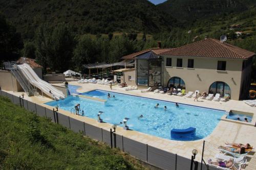 een groot zwembad met mensen erin bij Camping Les Prades in Mostuéjouls