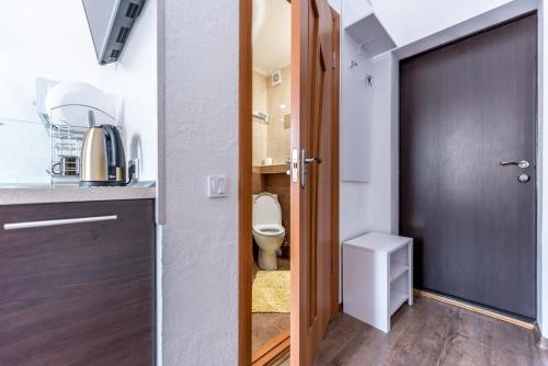 - une petite salle de bains avec des toilettes et une porte dans l'établissement Cozy studio in the heart of the city, à Odessa