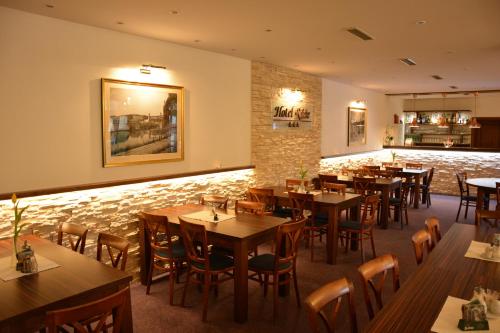 a restaurant with tables and chairs and a stone wall at Hotel Růže in Rožmberk nad Vltavou