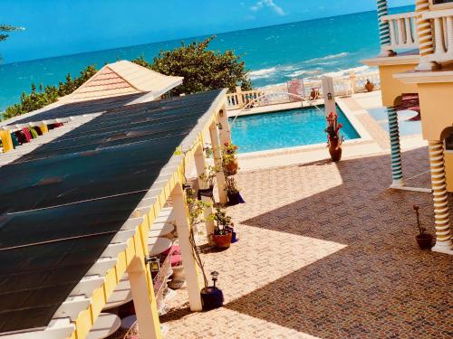 a building with a swimming pool next to the ocean at Taino Cove in Treasure Beach