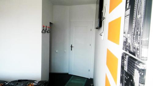 a hallway with a white door and a cross on the wall at Walk distance to mokotow business park in Warsaw