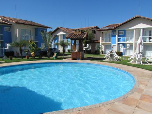 una gran piscina frente a algunas casas en Ap (Flat) Taperapuã Porto Seguro en Porto Seguro