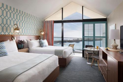 a hotel room with two beds and a desk at Dream Inn Santa Cruz in Santa Cruz