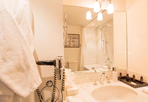 a white bathroom with a sink and a shower at Suitehotel Posthoorn in Monnickendam
