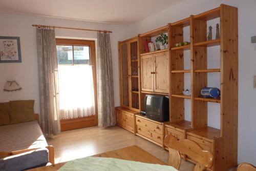 a living room with wooden cabinets and a tv at Haus Moosanger in Oberau