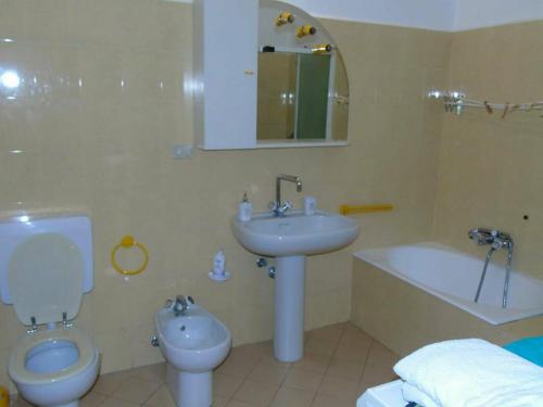 a bathroom with a toilet and a sink and a tub at La casa sul mare in Riva Ligure