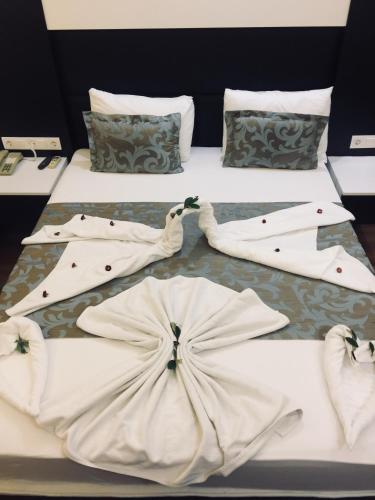 a couple of beds with white clothes on them at Grand Kayalar Hotel in Antalya