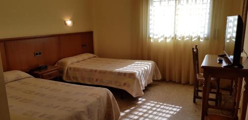 A bed or beds in a room at Hotel Reina Isabel