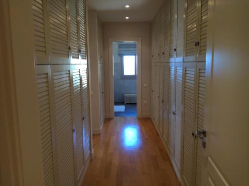 a hallway with wooden floors and white closet doors at Endless Blue in Anavissos