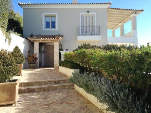 a white house with a pathway in front of it at Endless Blue in Anavissos