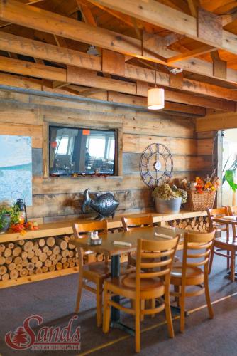 a dining room with wooden walls and a table and chairs at Sands on Golden Lake in Golden Lake