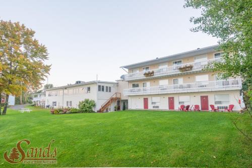 a large building with a lawn in front of it at Sands on Golden Lake in Golden Lake